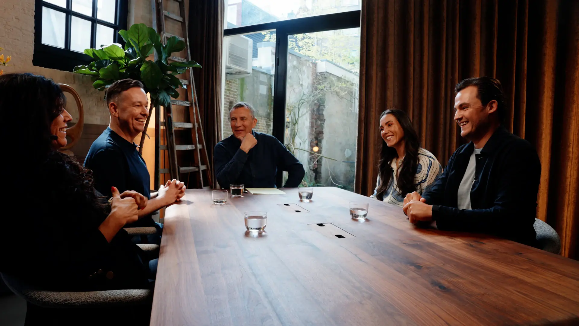 Twee mensen in gesprek aan een houten tafel